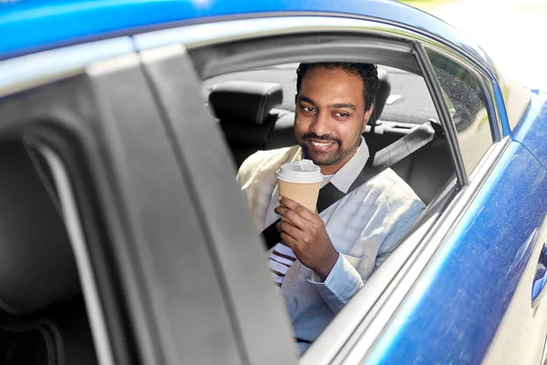 Індіанець з кавою на задньому сидінні автомобіля. — стокове фото