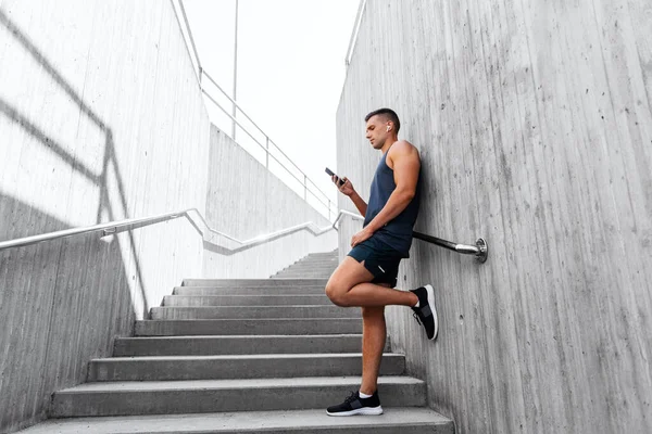 Young athlete man with earphones and smartphone — Stock Photo, Image