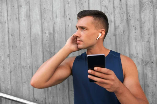 Joven atleta hombre con auriculares y teléfono inteligente —  Fotos de Stock