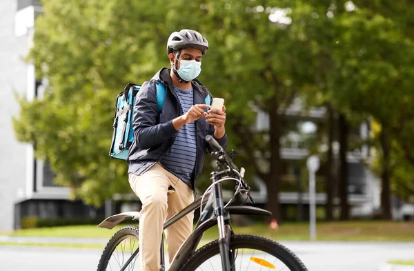 戴口罩的送货员，带着手机骑自行车 — 图库照片