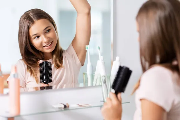 Ragazza adolescente che canta a spazzola per capelli in bagno — Foto Stock