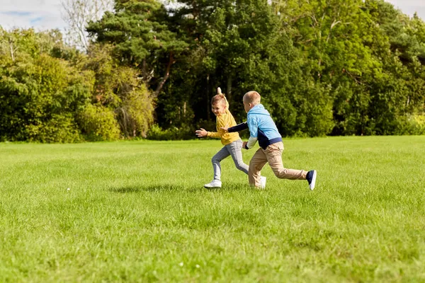 Twee gelukkige jongens spelen tag game in park — Stockfoto