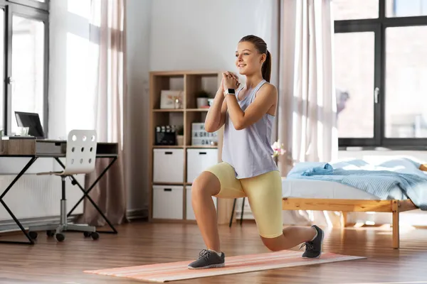 Evde yoga minderiyle egzersiz yapan mutlu genç kız. — Stok fotoğraf
