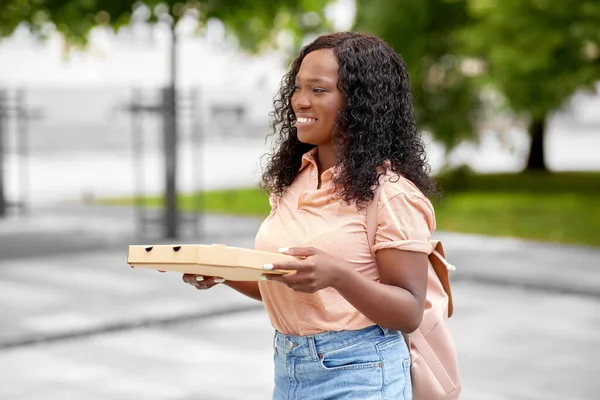 Африканская студентка с пиццей на вынос в городе — стоковое фото