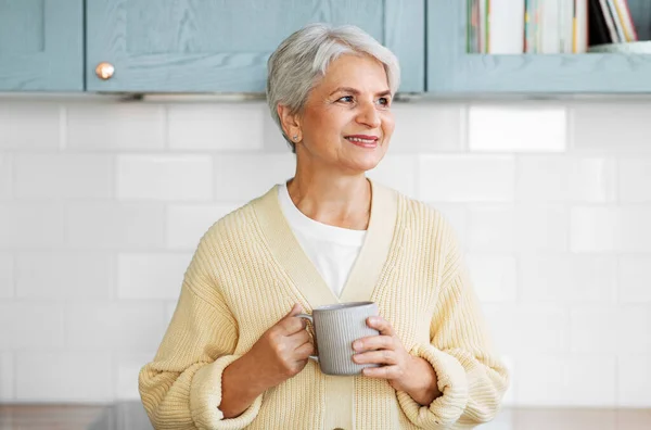 Femme heureuse avec tasse de café sur la cuisine à la maison — Photo
