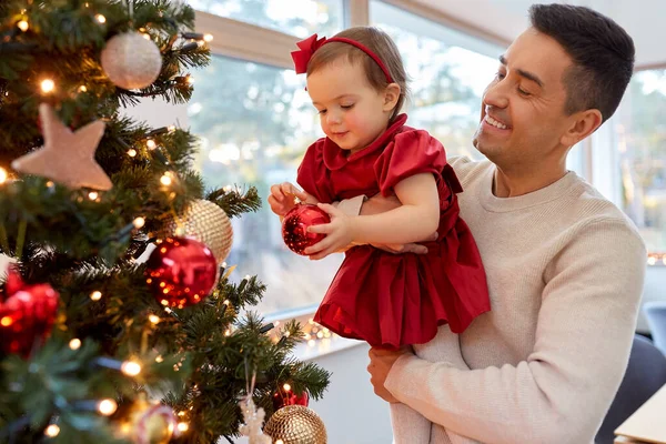 Mutlu baba ve kız bebek Noel ağacını süslüyor. — Stok fotoğraf