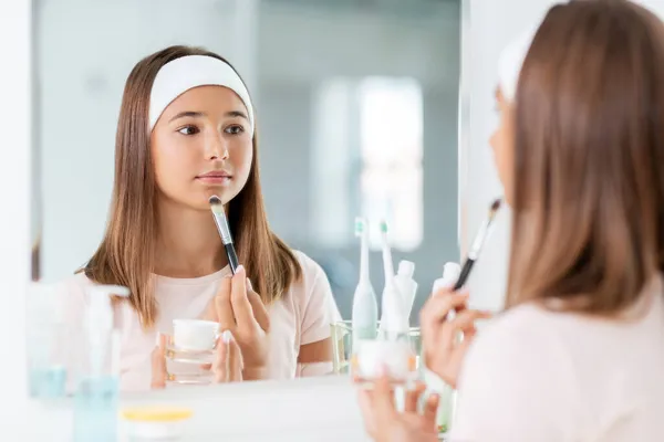 Adolescente aplicando máscara facial no banheiro — Fotografia de Stock