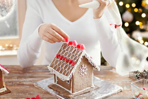 Nahaufnahme einer Frau, die Lebkuchenhaus herstellt — Stockfoto