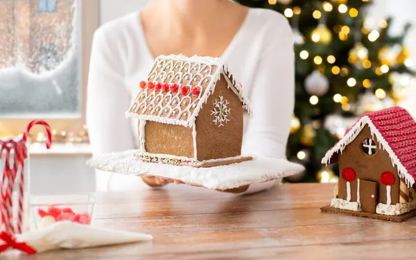 Gros plan de la femme tenant la maison de pain d'épice — Photo