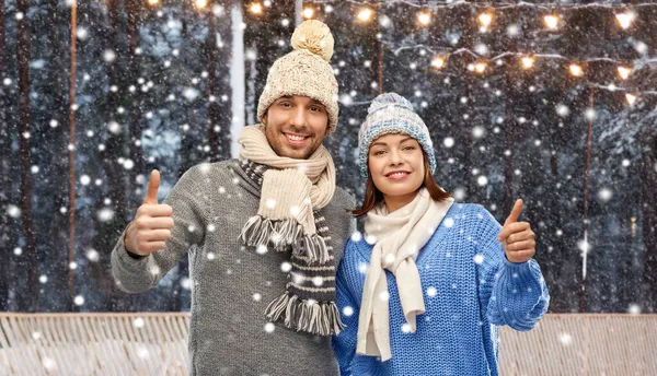 Šťastný pár v zimní oblečení zobrazující palce — Stock fotografie