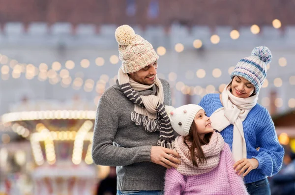 Šťastná rodina v zimních šatech na šedém pozadí — Stock fotografie