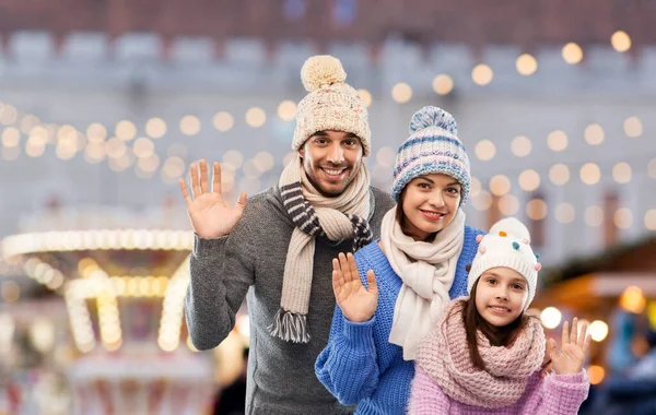 Familia feliz en ropa de invierno agitando las manos — Foto de Stock