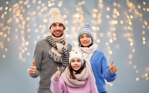 Glückliche Familie in Winterkleidung auf grauem Hintergrund lizenzfreie Stockbilder