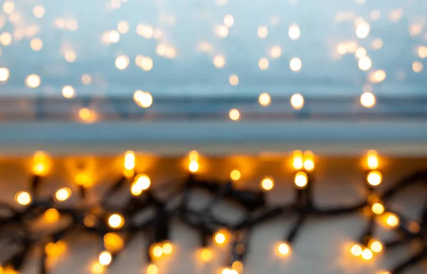Luces de guirnalda eléctrica borrosa en alféizar de ventana — Foto de Stock