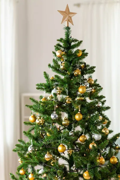 Украшенная искусственная рождественская елка дома — стоковое фото
