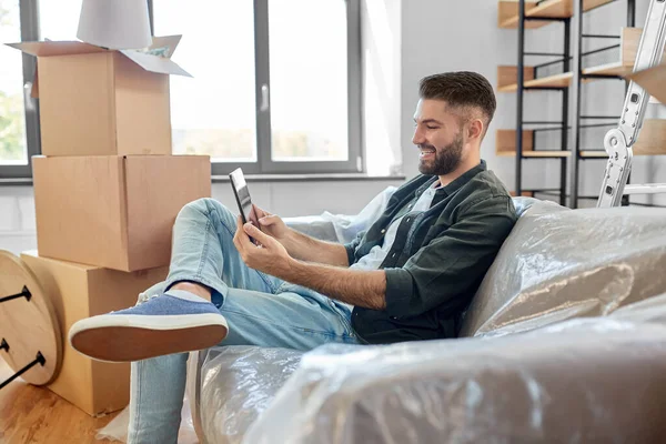 Hombre con la tableta PC y cajas que se mueven en el nuevo hogar — Foto de Stock