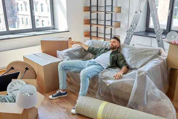 Втомлений чоловік з коробками переїжджає в новий будинок — стокове фото