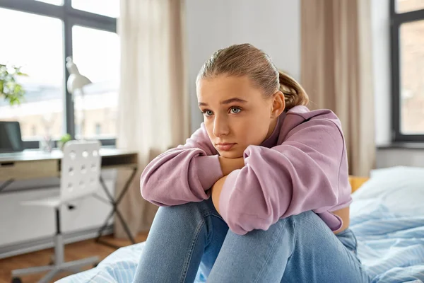 Chica triste sentada en la cama en casa — Foto de Stock