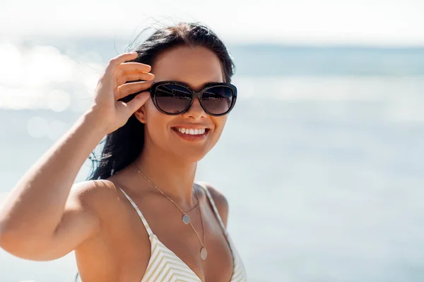 Glimlachende jonge vrouw in bikini badpak op het strand — Stockfoto