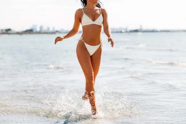 Młoda kobieta w bikini strój kąpielowy na plaży — Zdjęcie stockowe