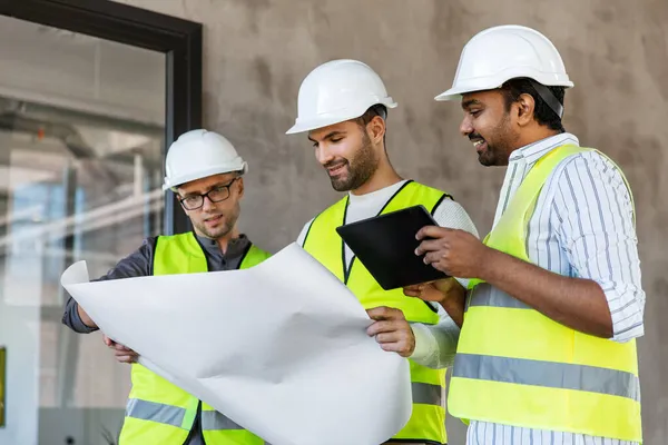 Arquitectos con plano en edificio de oficinas — Foto de Stock