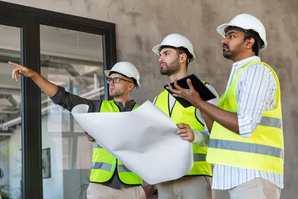 Architekten mit Bauplan im Bürogebäude — Stockfoto