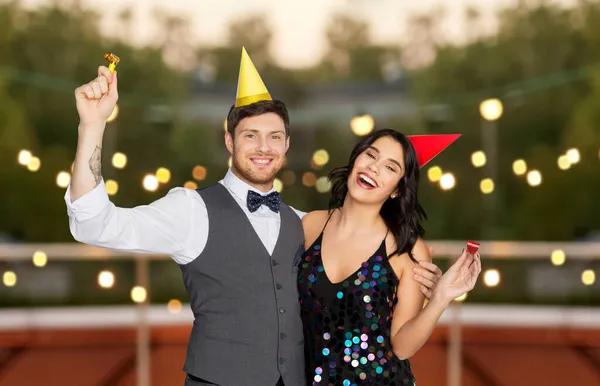 Glückliches Paar mit Party-Blowern, die Spaß haben — Stockfoto