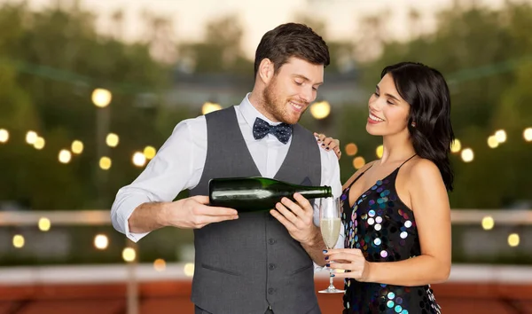 Šťastný pár se šampaňským a sklo na party — Stock fotografie