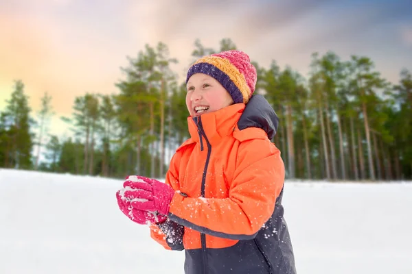 Счастливая девушка играет со снегом зимой — стоковое фото