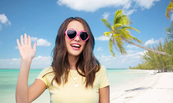 Szczęśliwa kobieta w okularach przeciwsłonecznych w kształcie serca na plaży — Zdjęcie stockowe
