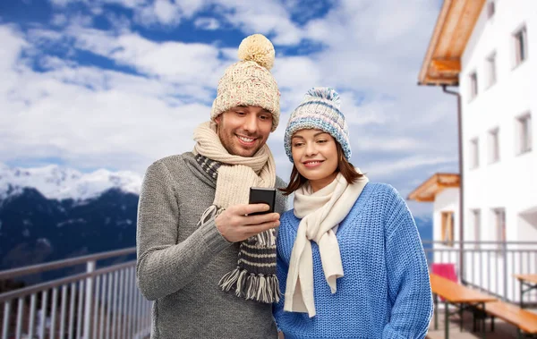 Счастливая пара со смартфоном зимой — стоковое фото