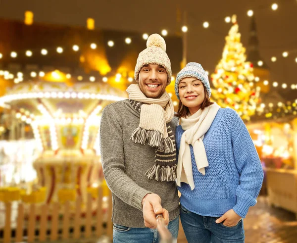 Щаслива пара в зимовому одязі приймає селфі — стокове фото