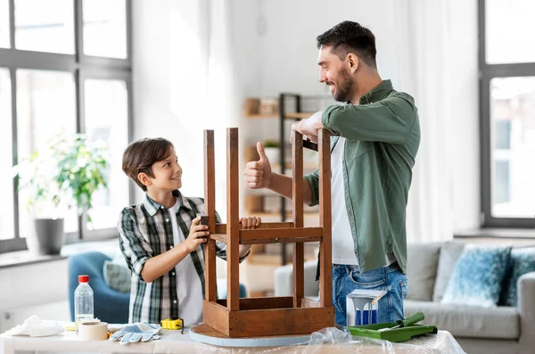 Pai e filho lixar mesa velha com esponja — Fotografia de Stock
