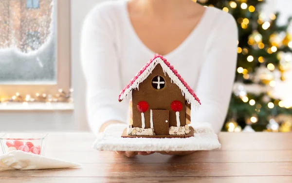 Close up of woman holding gingerbread house — Stock Photo, Image