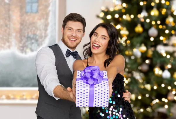 Feliz pareja con caja de regalo en la fiesta de Navidad —  Fotos de Stock