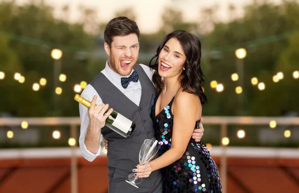 Casal feliz com champanhe e copos na festa — Fotografia de Stock