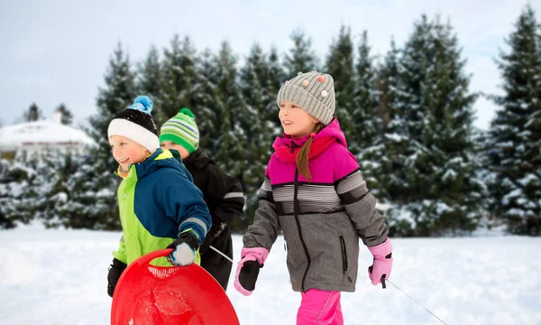 Счастливые маленькие дети с санками на улице зимой — стоковое фото