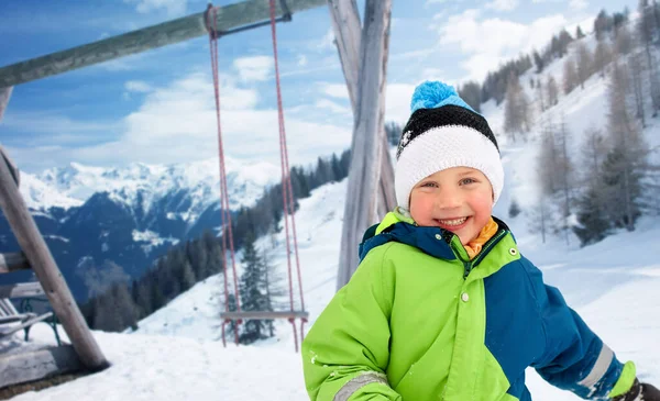 Happy little boy in winter clothes over mountains — Stock Photo, Image
