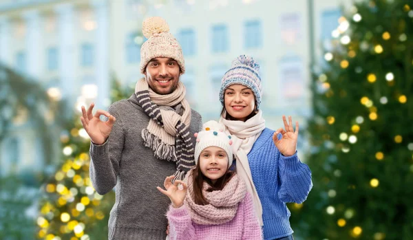 Šťastná rodina v zimních šatech se zobrazeným pohybem OK — Stock fotografie