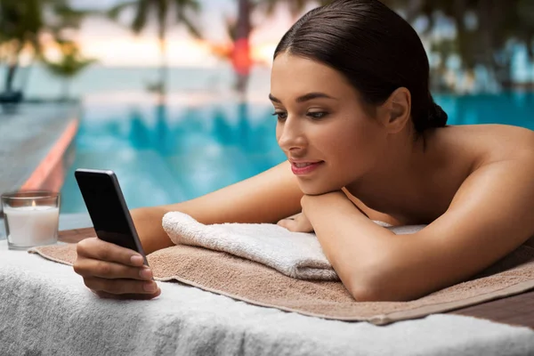 Frau mit Smartphone im Wellness- oder Massagesalon — Stockfoto