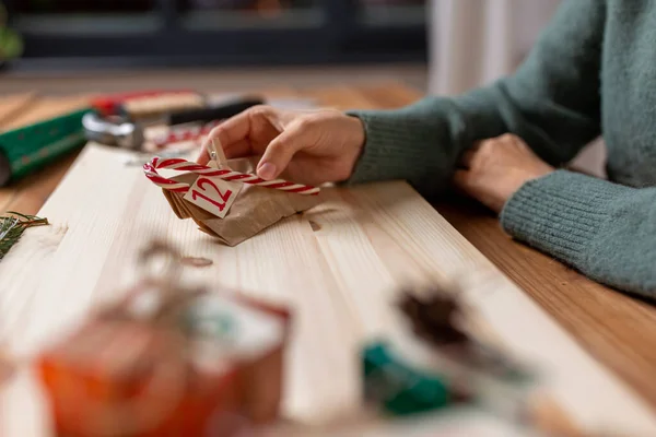 Manos haciendo calendario de adviento de Navidad en casa — Foto de Stock