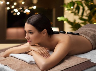 woman having hot stone massage at spa clipart