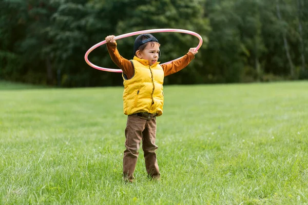 Χαρούμενο αγοράκι που παίζει με την χούλα χουπ στο πάρκο. — Φωτογραφία Αρχείου