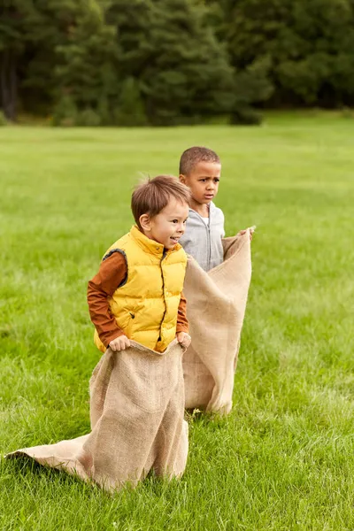 Szczęśliwy chłopcy grać torba skoki gra w parku — Zdjęcie stockowe
