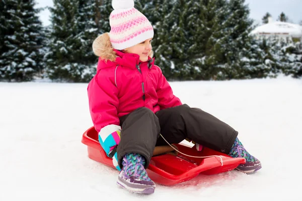 Šťastná holčička na saních venku v zimě — Stock fotografie