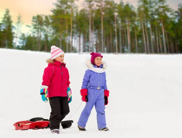 Happy little girls with sleds walking in winter — Stock Photo, Image