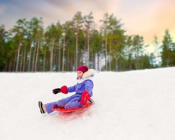 Menina deslizando para baixo no disco de neve trenó no inverno — Fotografia de Stock