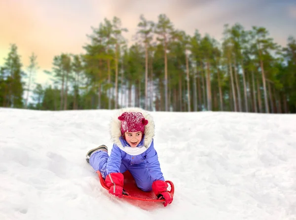 冬天的女孩滑倒在雪碟雪橇上 — 图库照片