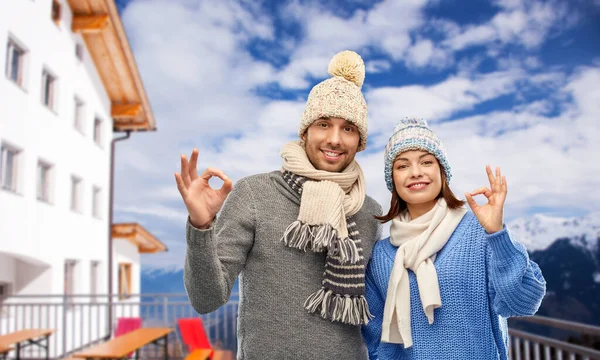 Счастливая пара показывает хороший знак зимой — стоковое фото