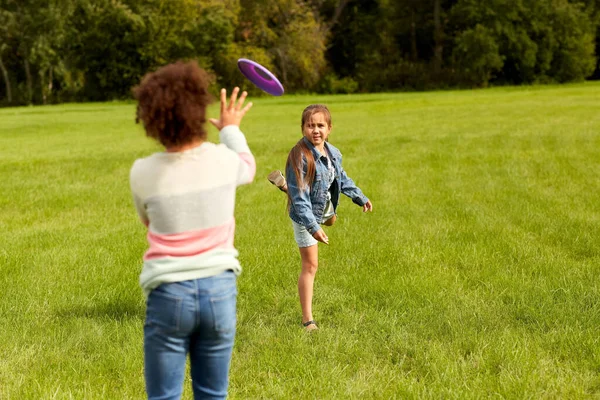 Niñas felices jugando con el disco volador en el parque —  Fotos de Stock